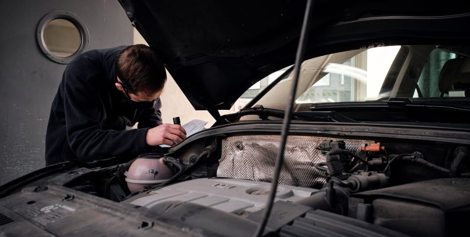 Mecánico revisando el compartimento del motor de un coche